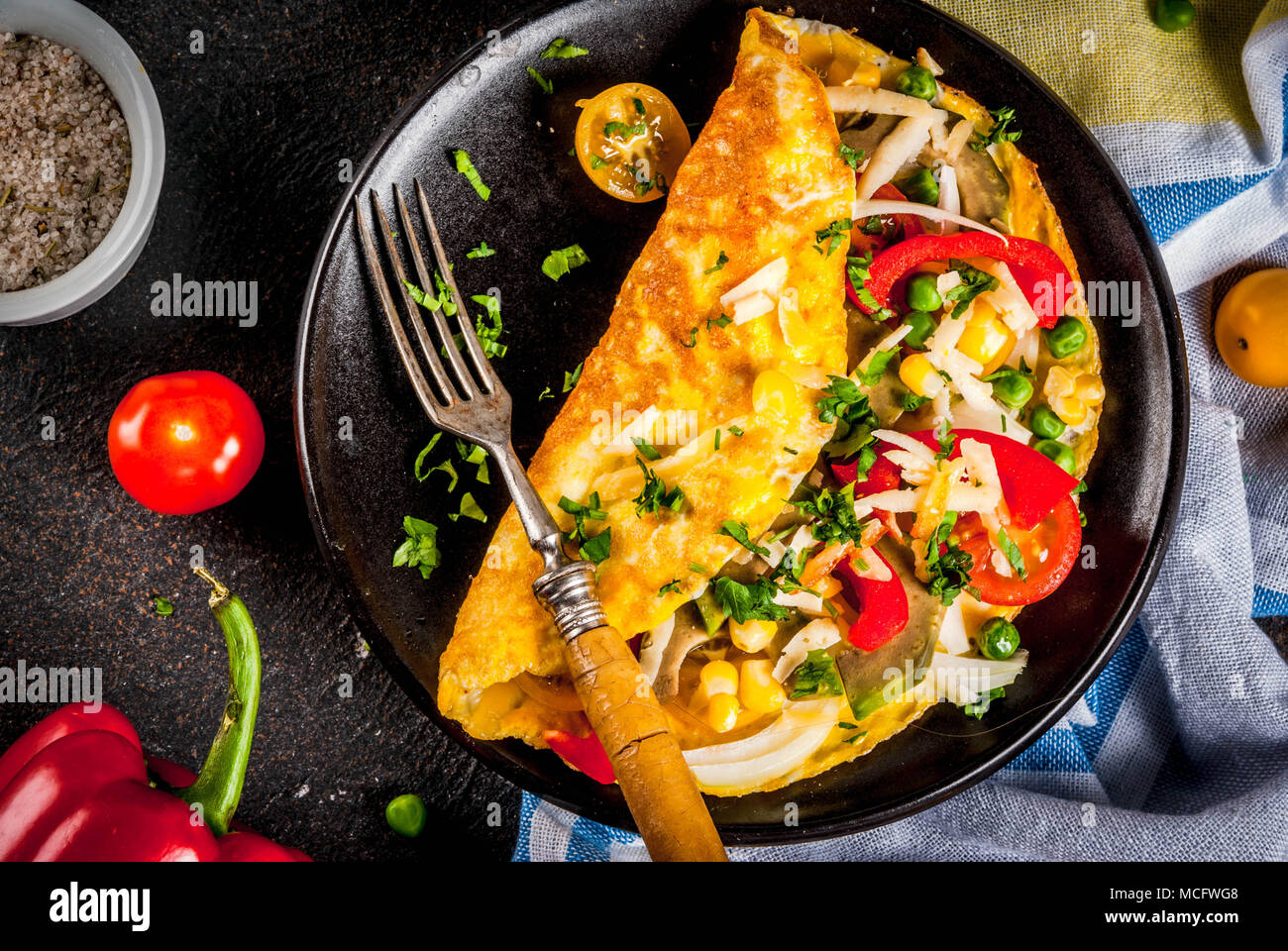 Una sana prima colazione il cibo, farcite frittata di uova con verdure, scuro dello sfondo concreto spazio copia vista superiore Foto Stock