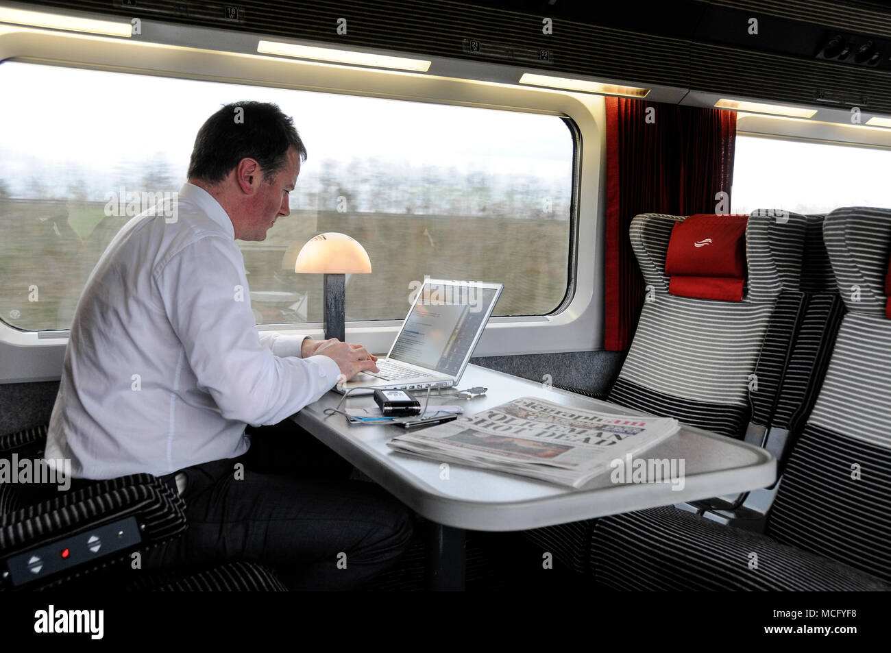 Un uomo d'affari che fa colazione nel compartimento di classe 1st di un treno interurbano che parte da Dublino, Irlanda, per Belfast Foto Stock