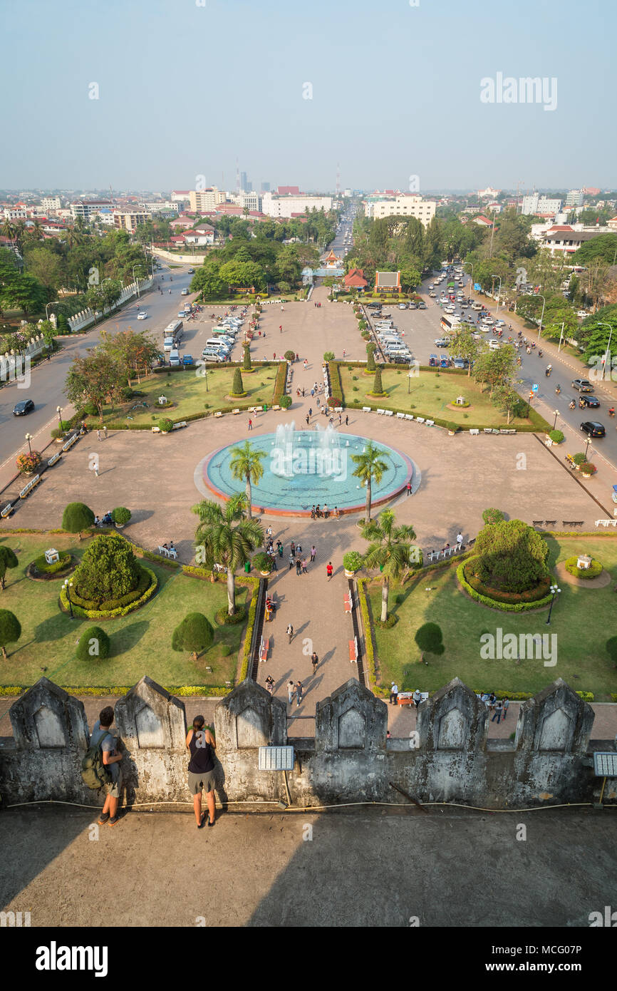 Vista di due turisti al Patuxai (Vittoria gate o gate del trionfo) monumento, la gente al Patuxai Park e al di là dal di sopra di Vientiane, Laos. Foto Stock
