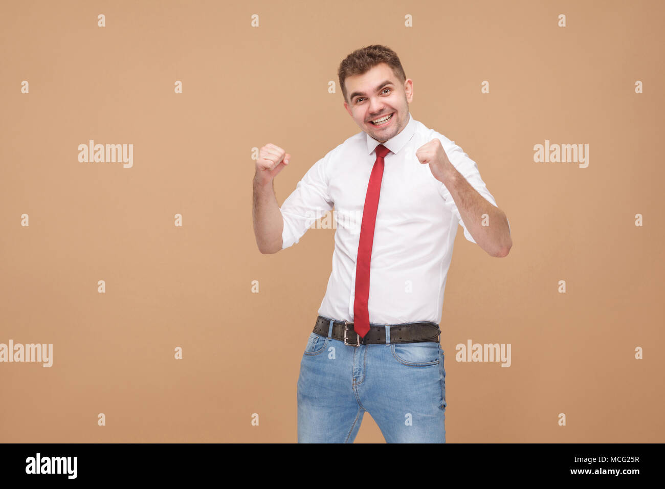 La felicità imprenditore esultanza win. La gente di affari concetto buone e cattive emozioni e sentimenti. Studio shot, isolato sulla luce sfondo marrone Foto Stock
