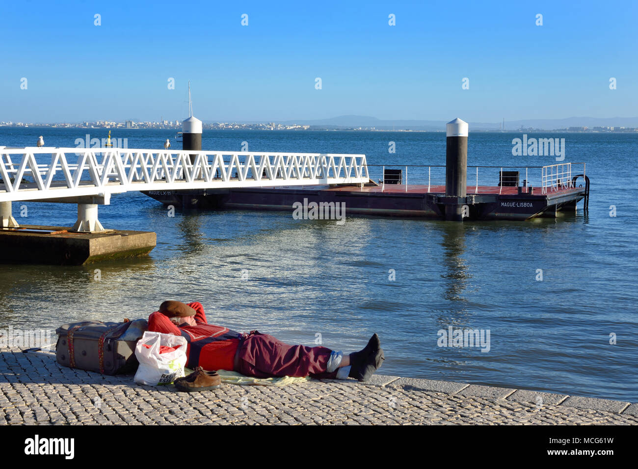 Dormire, Wanderer, Fiume Tagus waterfront promenade caffetterie e relax, Lisbona - Lisboa, Portogallo portoghese. Foto Stock