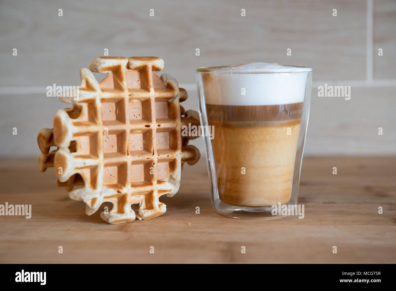 Le coppe di vetro di caffè multistrato con mini stroopwafel, syrupwaffles cookie su sfondo grigio chiaro con copia spazio. waffle cookies Foto Stock
