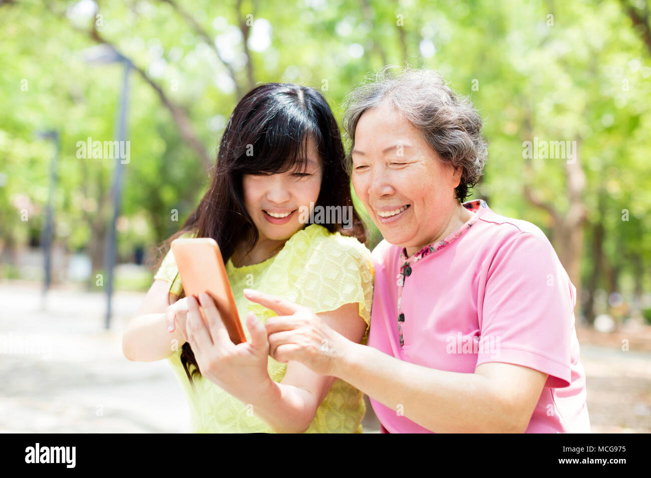 Felice senior madre e figlia che guarda la smart phone Foto Stock