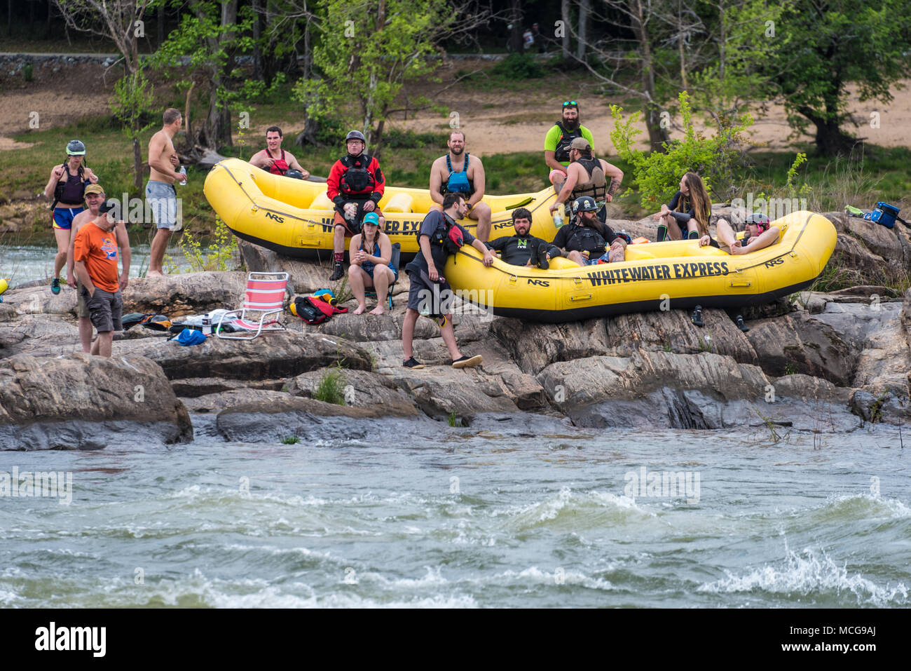 Whitewater rafters guardare gli Stati Uniti Kayak Freestyle campionato nazionale da un'isola rocciosa nel fiume Chattahoochee a Columbus, Georgia. Foto Stock