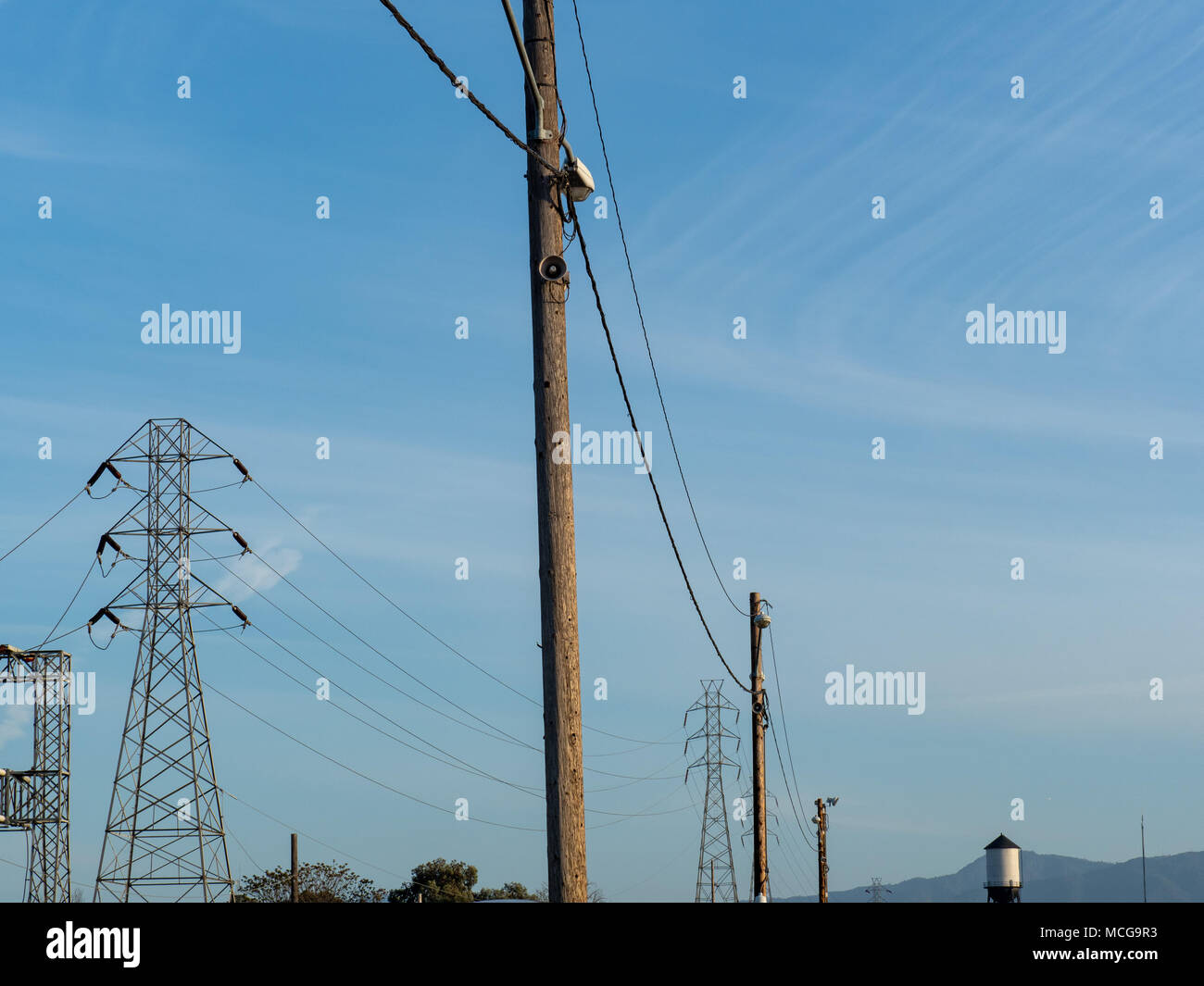 Le linee di alimentazione stand alto durante lo stiramento all'orizzonte in una giornata di sole Foto Stock