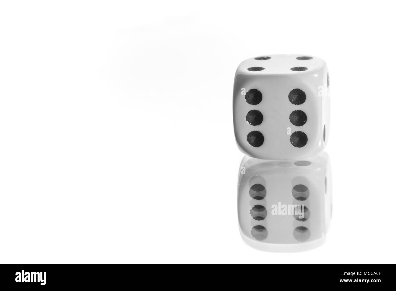 Dadi bianco con numero nero 6 su sfondo bianco con finitura a specchio Foto Stock