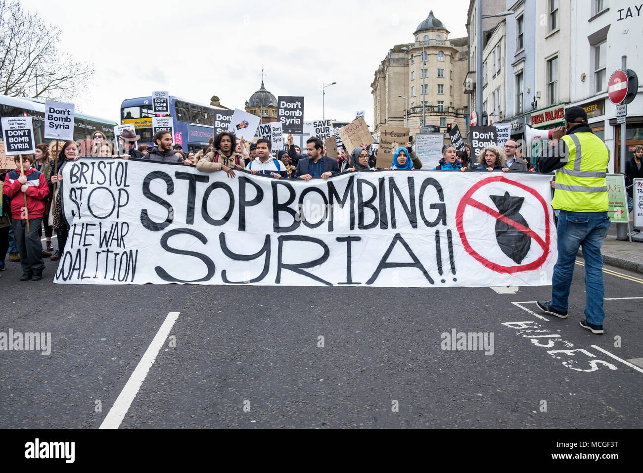 Bristol, Regno Unito. 16 Aprile, 2018. I manifestanti che trasportano 'non bombardare la Siria' cartelloni sono illustrati in quanto essi marzo attraverso Bristol durante un bombardamento di arresto Siria marcia di protesta. Il rally e il mese di marzo è stato organizzato dalla Bristol a fermare la guerra coalizione per protestare contro il governo del Regno Unito hanno le incursioni aeree in Siria. Credito: lynchpics/Alamy Live News Foto Stock