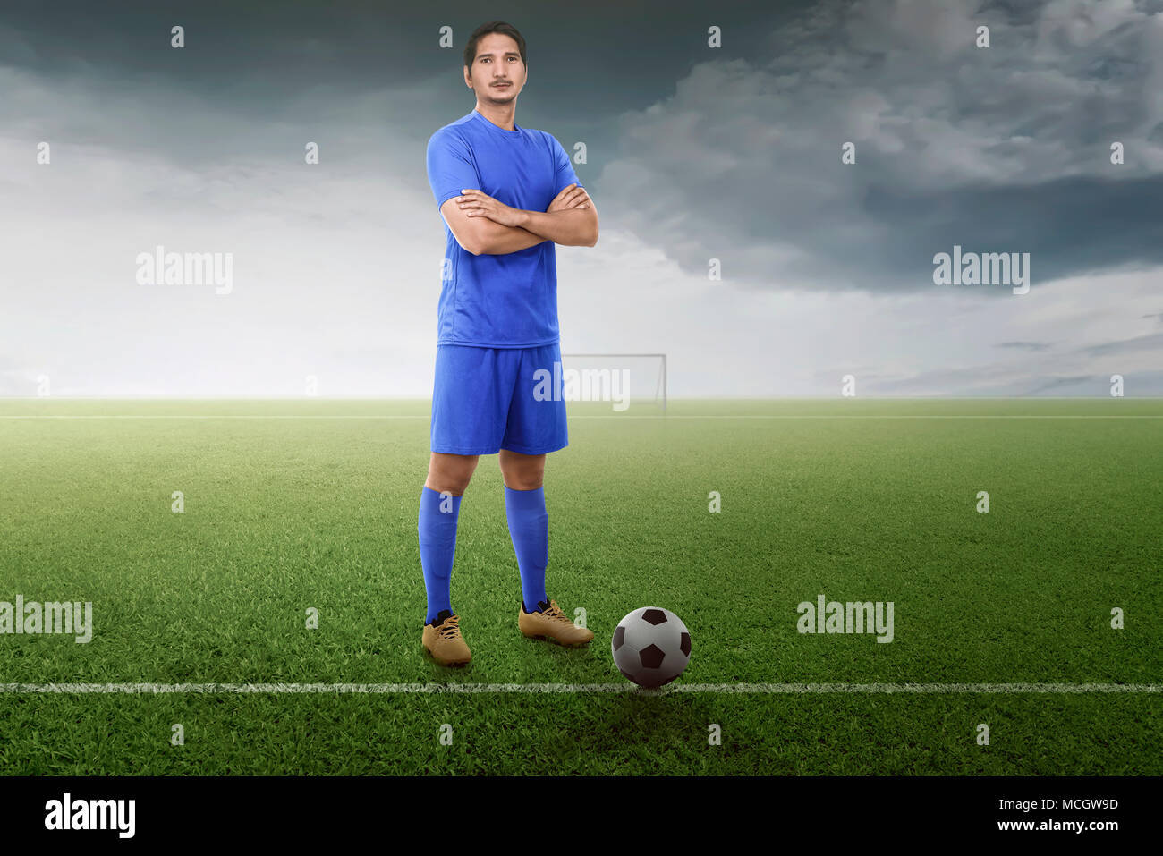 Professional asian giocatore di football con sfera pronto per giocare la partita sul campo Foto Stock