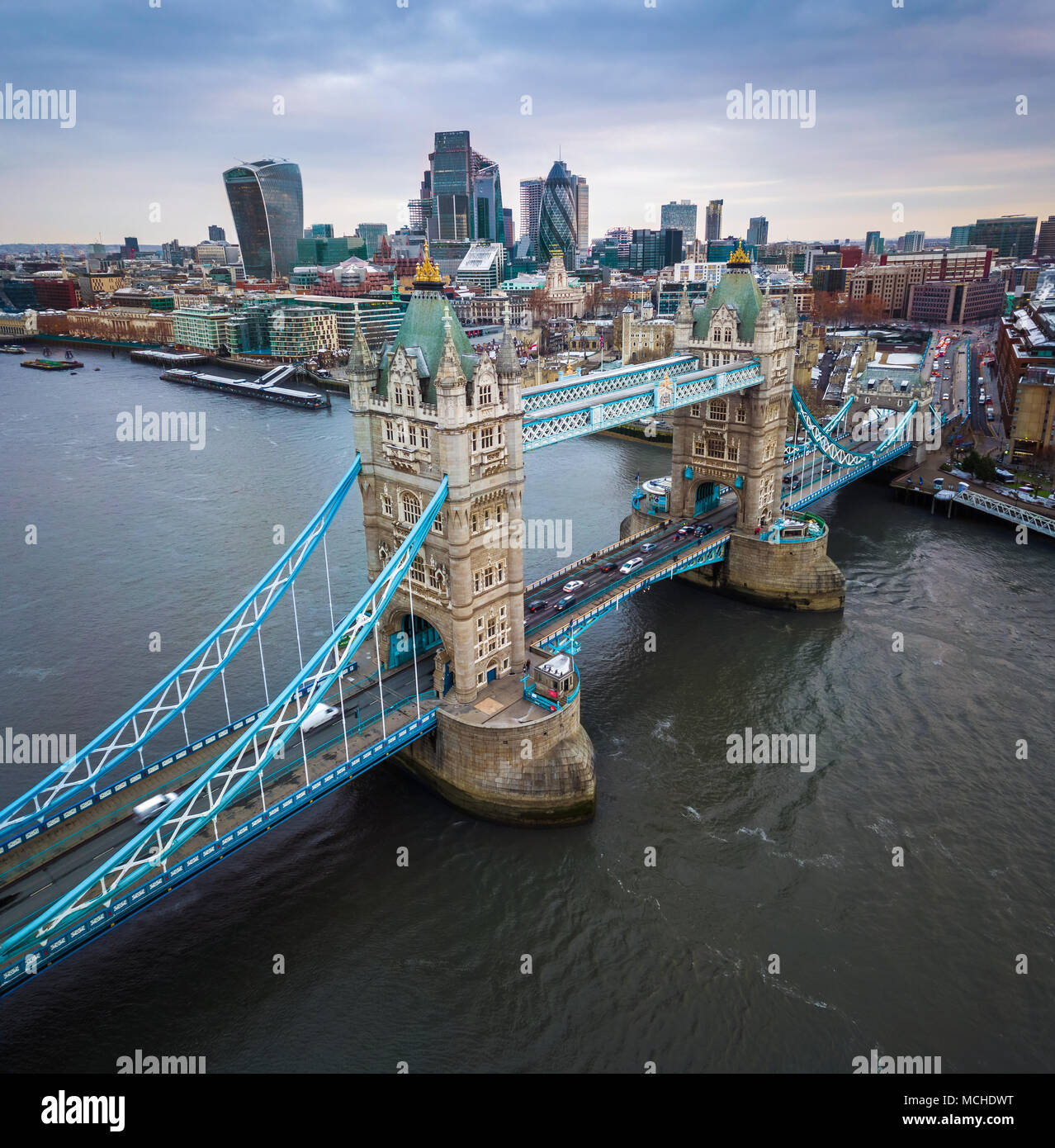 Londra, Inghilterra - Antenna vista panormaic dell'iconico il Tower Bridge e la Torre di Londra su una mattina nuvoloso con grattacieli della banca finanziaria distr Foto Stock