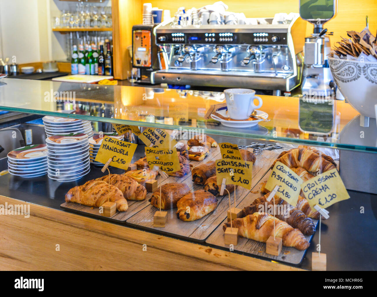 Una colazione italiana contatore con diversi gusti di croissant. Macchina per il caffè in background. Foto Stock
