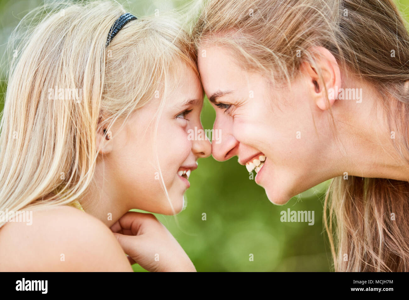 Felice madre e figlia guardare in profondità in ciascuna negli occhi nel verde Foto Stock