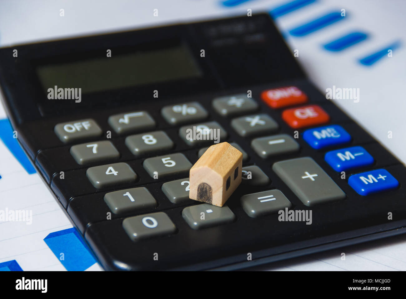 Prestiti ipotecari di concetto con casa in legno e Calcolatrice su sfondo bianco con schema Foto Stock