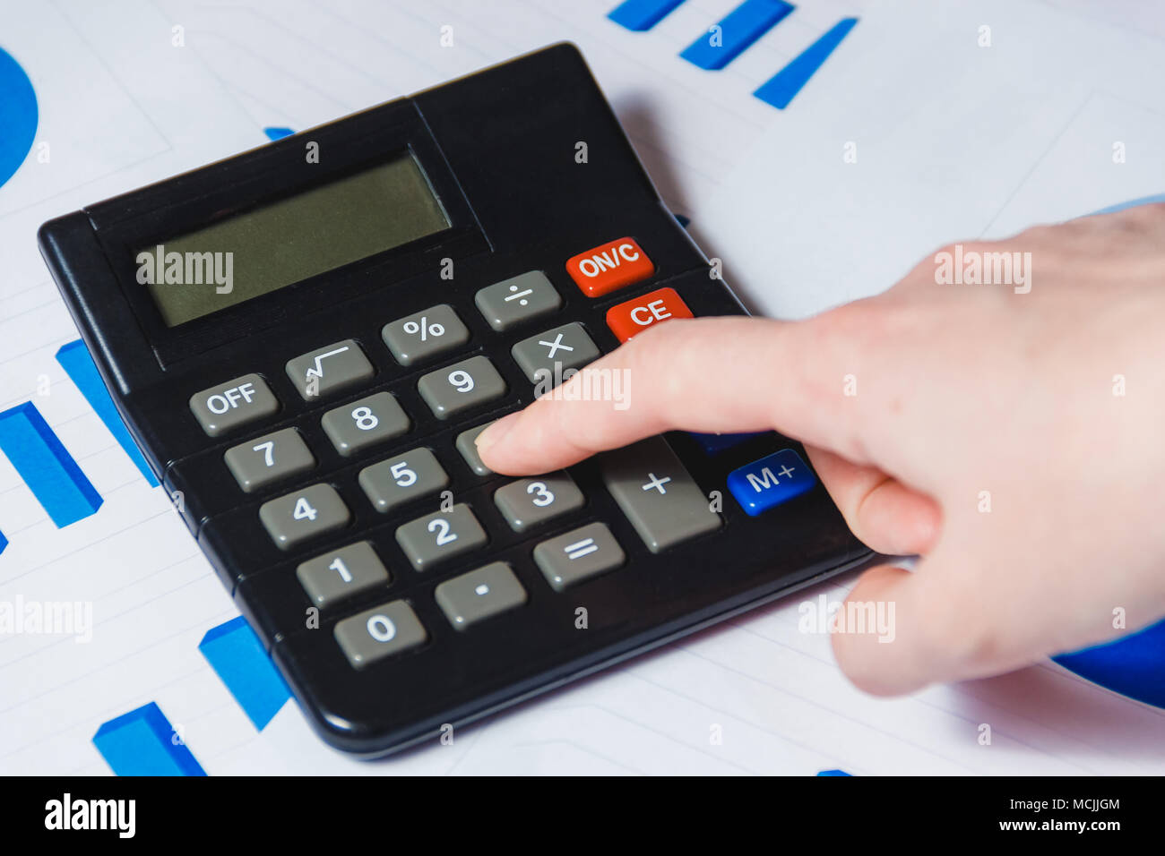 Close-up di donna mano utilizzando la Calcolatrice sulla scrivania con schema Foto Stock