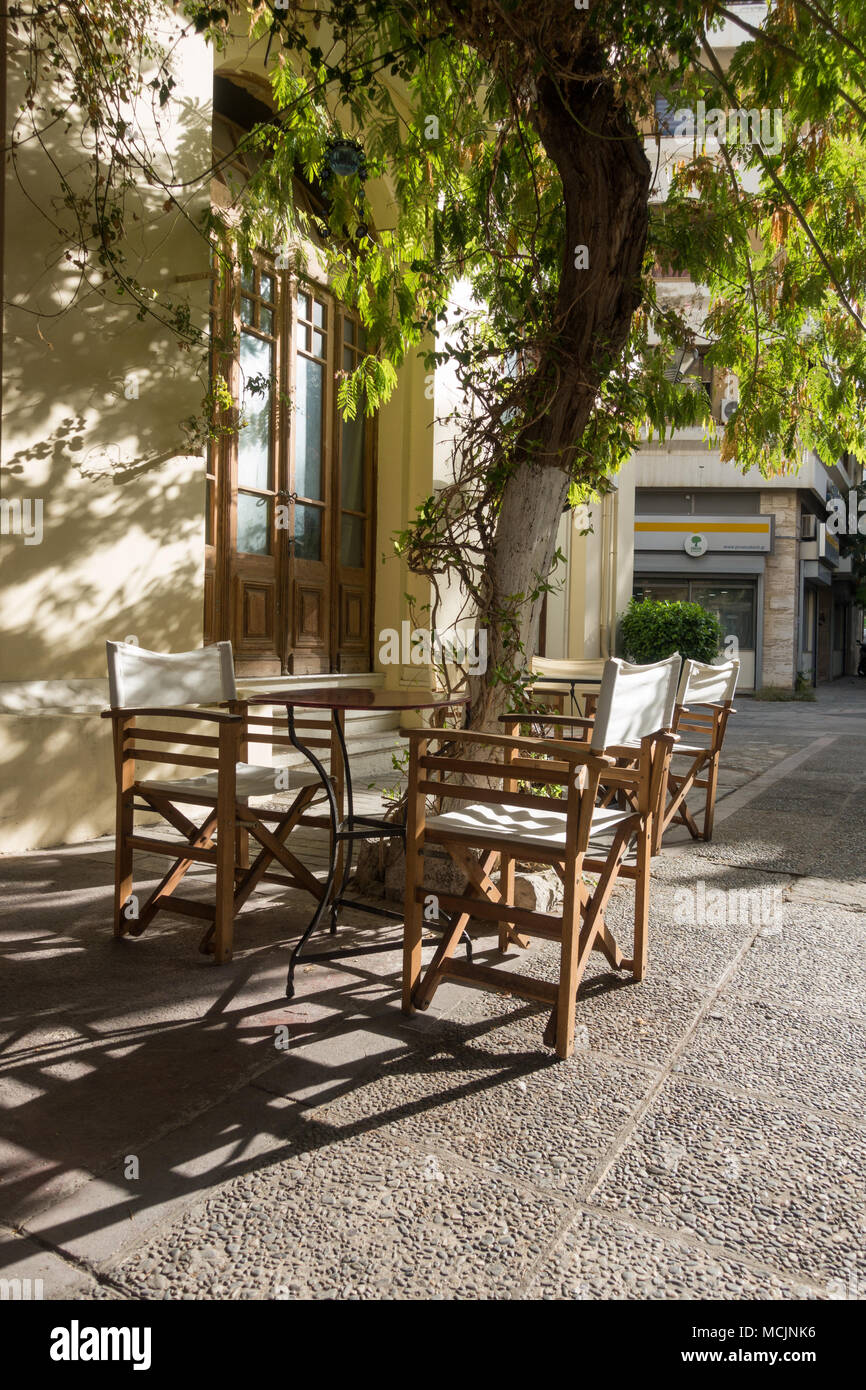 Vista del vuoto e i tavoli e le sedie in outdoor cafe, Heraklion, Grecia Foto Stock