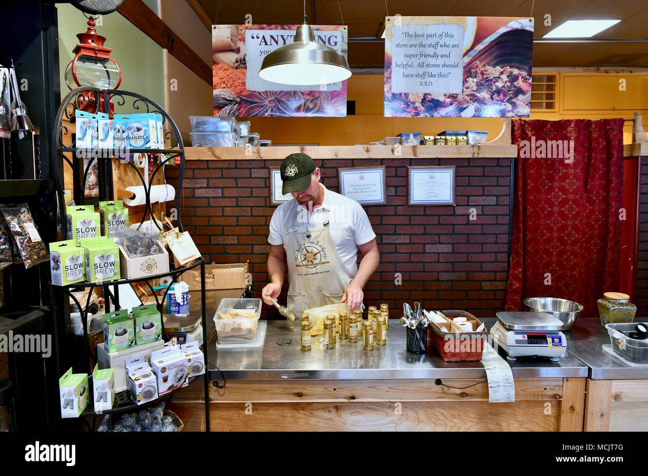Dipendente di spezie di riempimento di bottiglie in un custom blend spice store in Rehoboth Beach, Delaware, STATI UNITI D'AMERICA Foto Stock