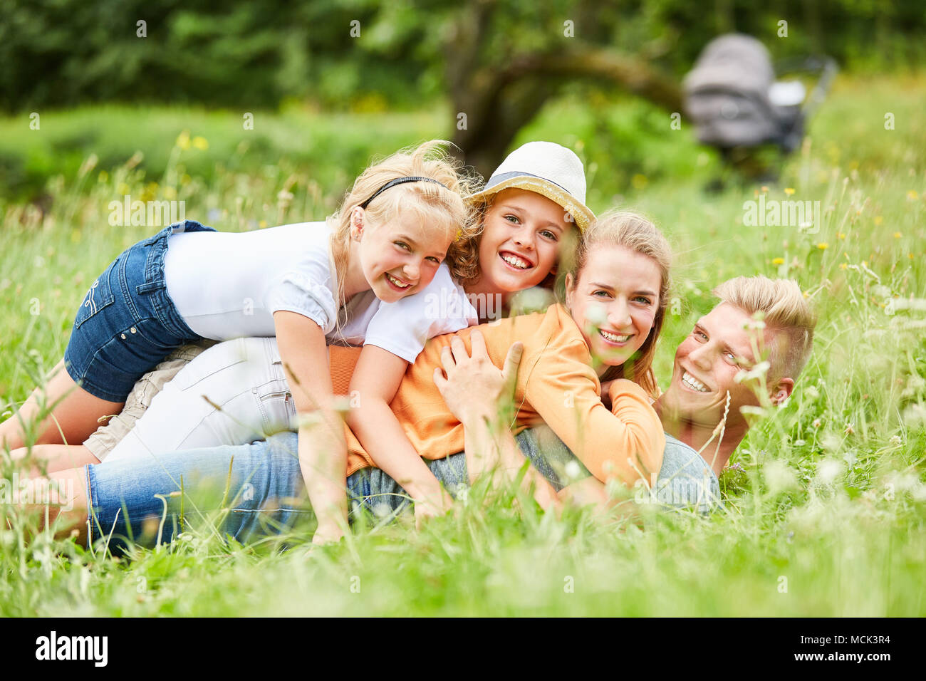 La famiglia e i bambini coccola e divertirsi insieme in giardino Foto Stock