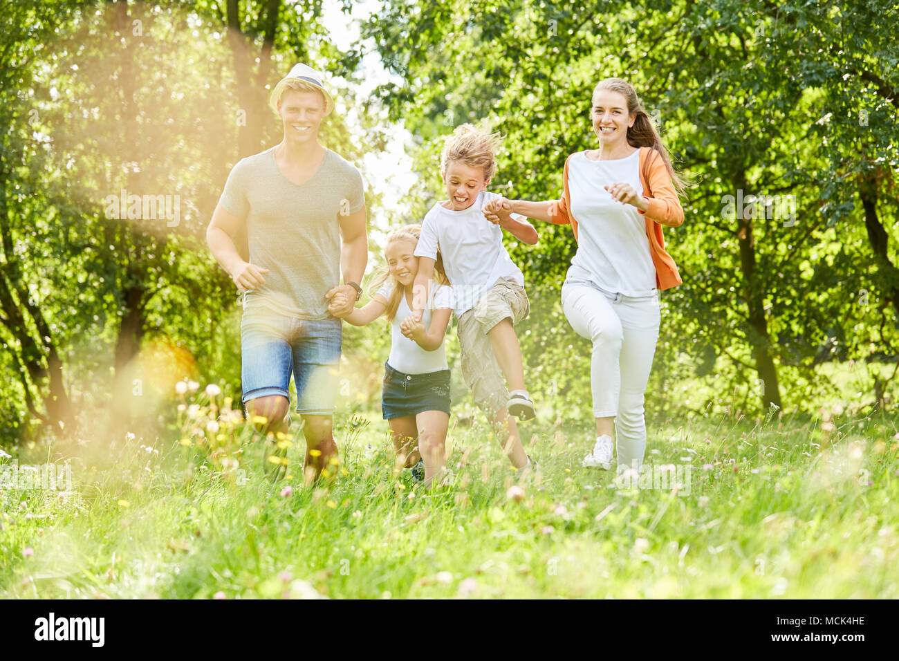 La famiglia felice ha divertimento in natura nel giardino in estate Foto Stock