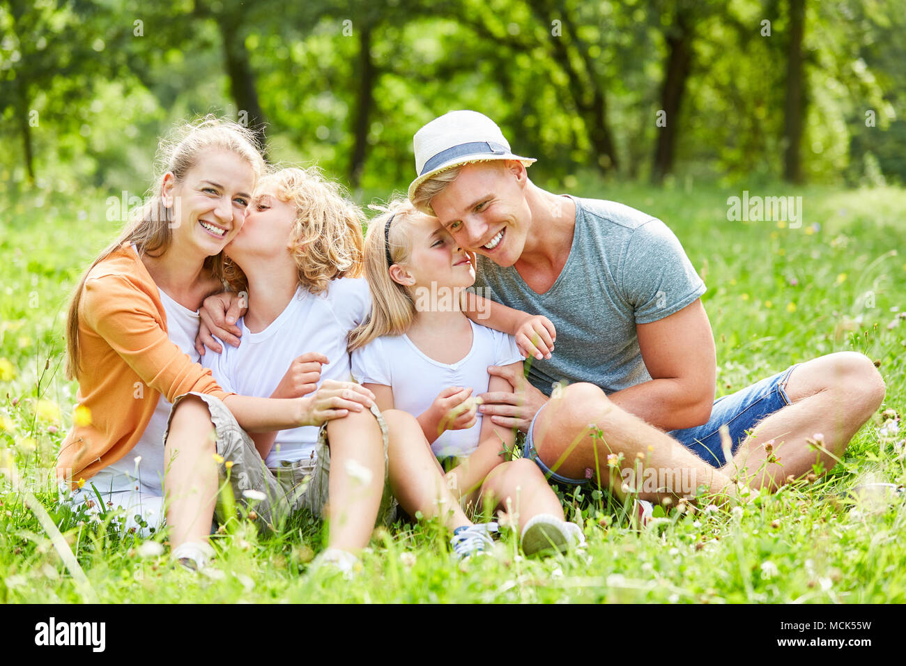 La famiglia felice e due bambini è seduta rilassante nella natura Foto Stock