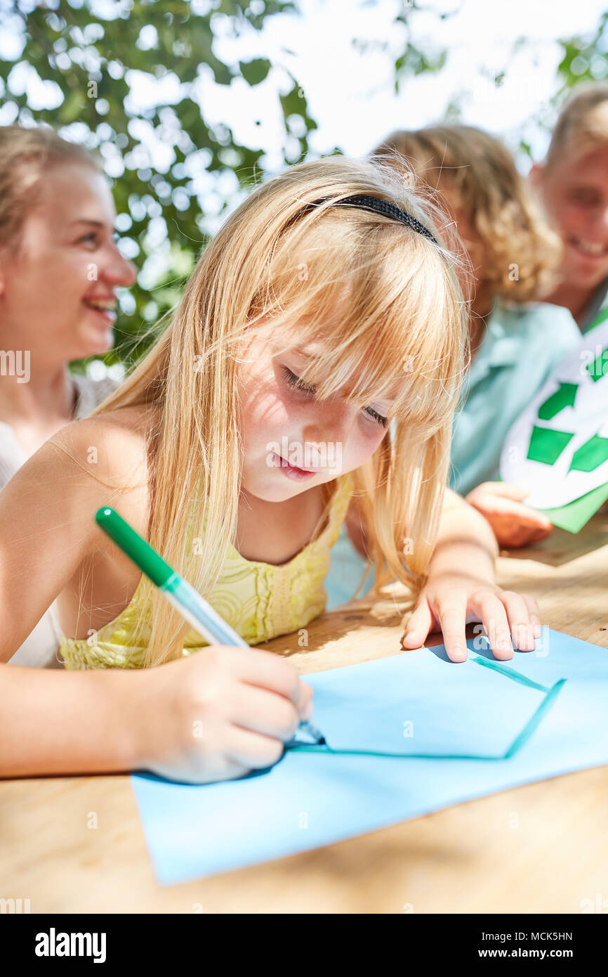 Ragazza dipinge e disegna una casa come un simbolo della costruzione di casa e home Foto Stock