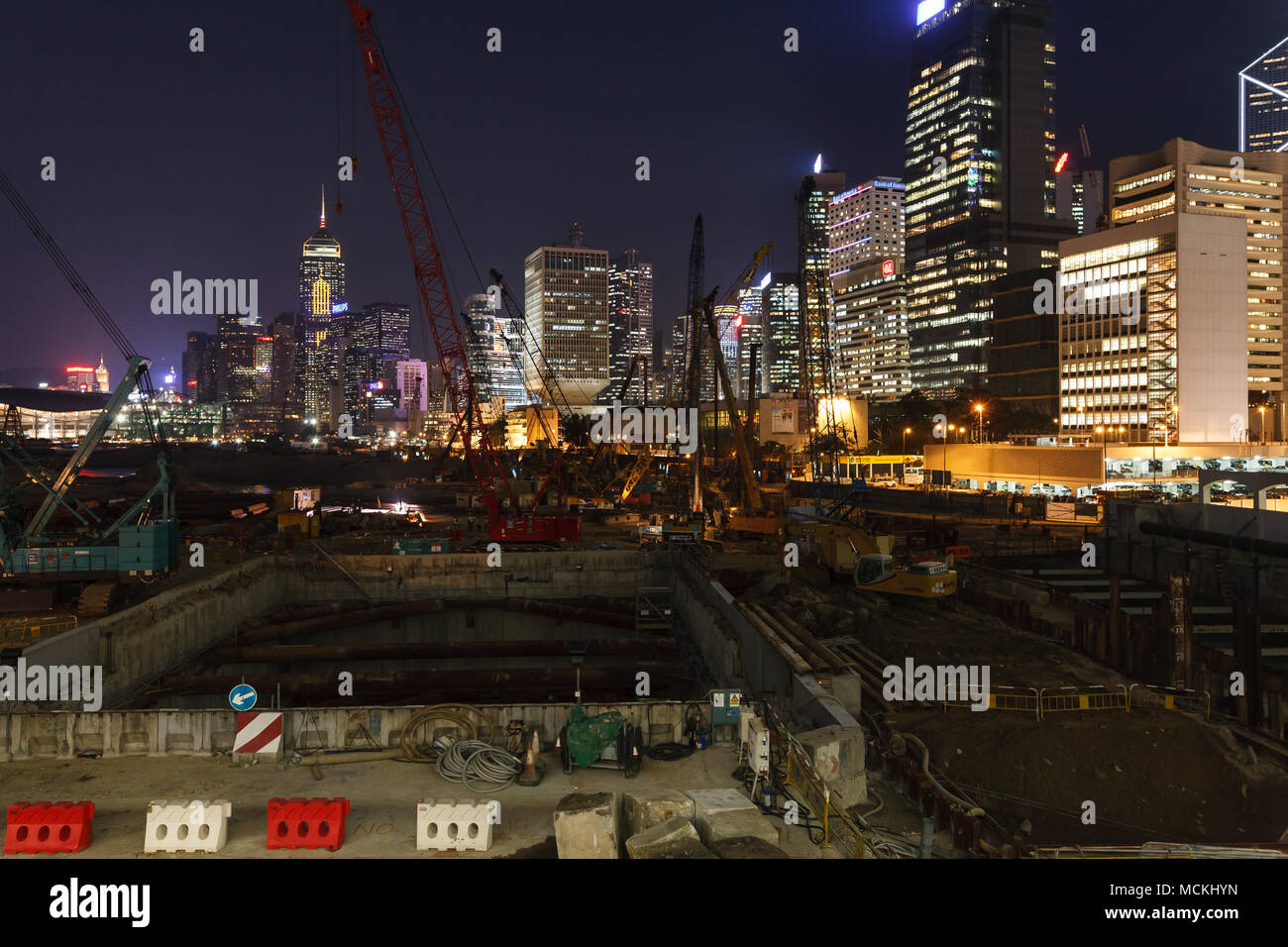 Costruzione sull isola di Hong Kong con vista sul lungomare di notte con lo skyline della città illuminata con luci colorate Foto Stock