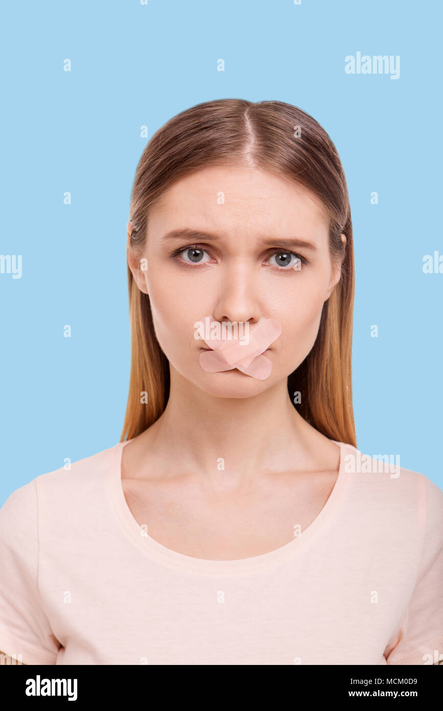 Triste donna avente bocca chiusa con bendaggi adesivi Foto Stock