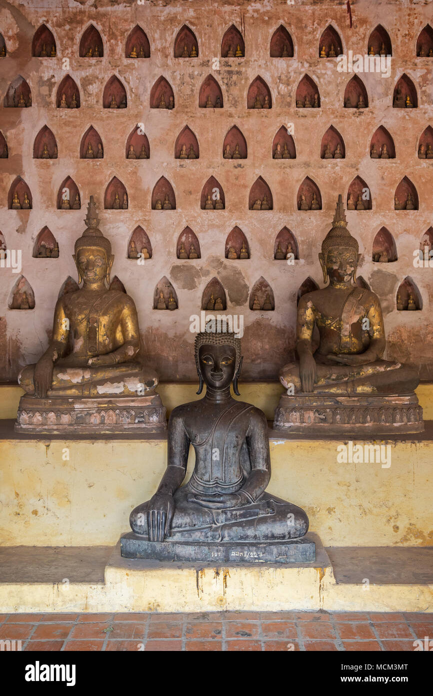 Vista frontale di tre vecchi e di età compresa tra statue di Buddha a Wat Si Saket (Sisaket) tempio della clausura in Vientiane, Laos. Foto Stock
