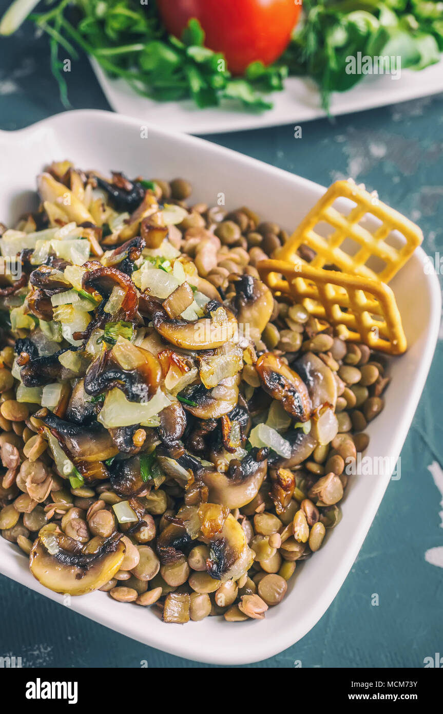 Mediterraneo tradizionale insalata di lenticchie e una fetta di cetriolo e insalata verde e foglie di dragoncello. La vista dall'alto. Foto Stock