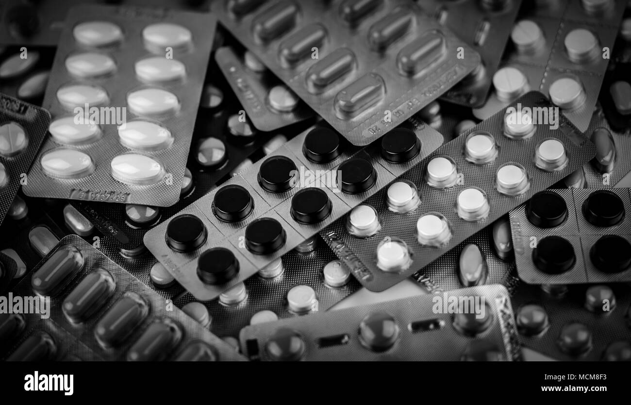 Telaio completo di pila di foto in bianco e nero di pillole compresse in blister. Avvelenamento da farmaco concetto di gestione. Cumulo di carbone di legna compresse e pillole. Foto Stock
