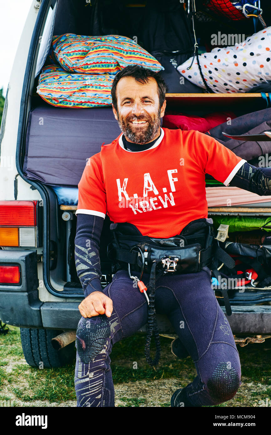 Un ritratto di stile di vita di un kite surfer seduta al di fuori del suo camper Foto Stock