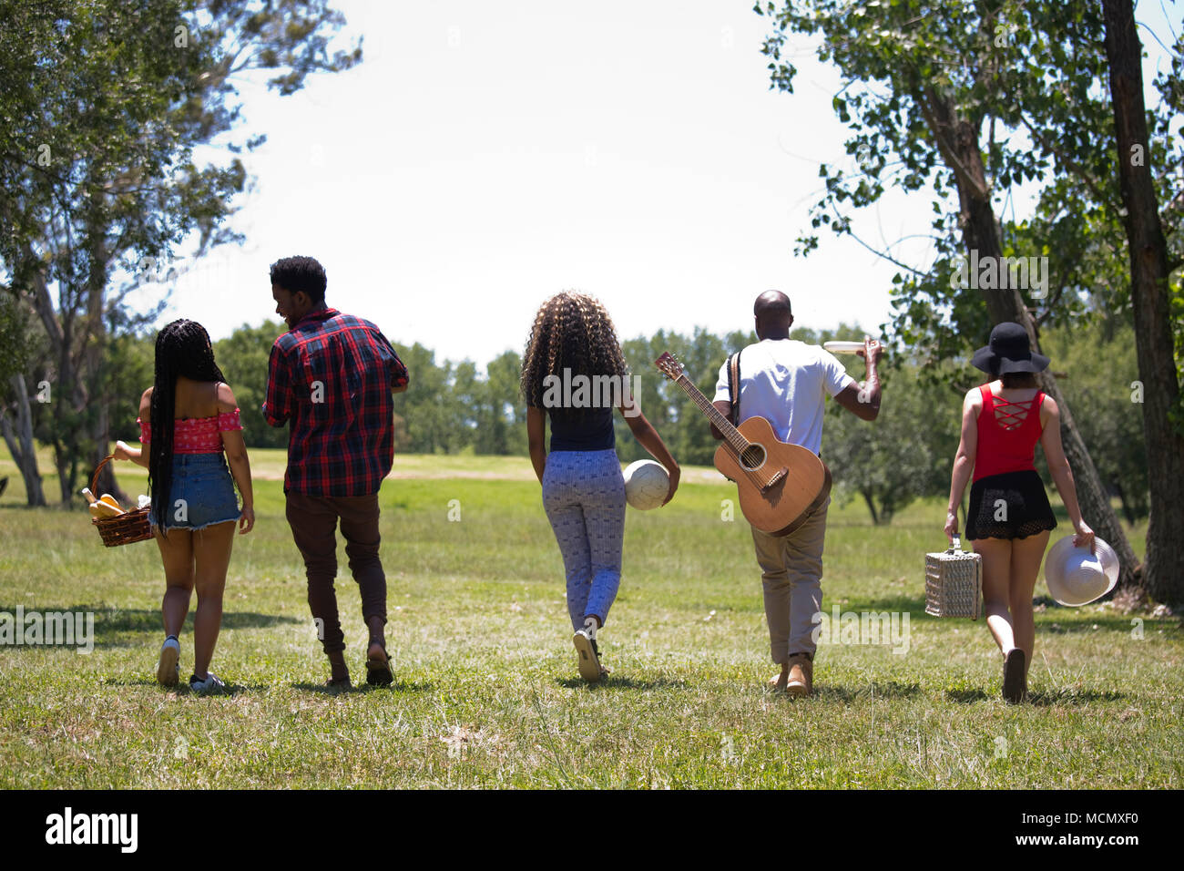 Amici a piedi per un picnic Foto Stock