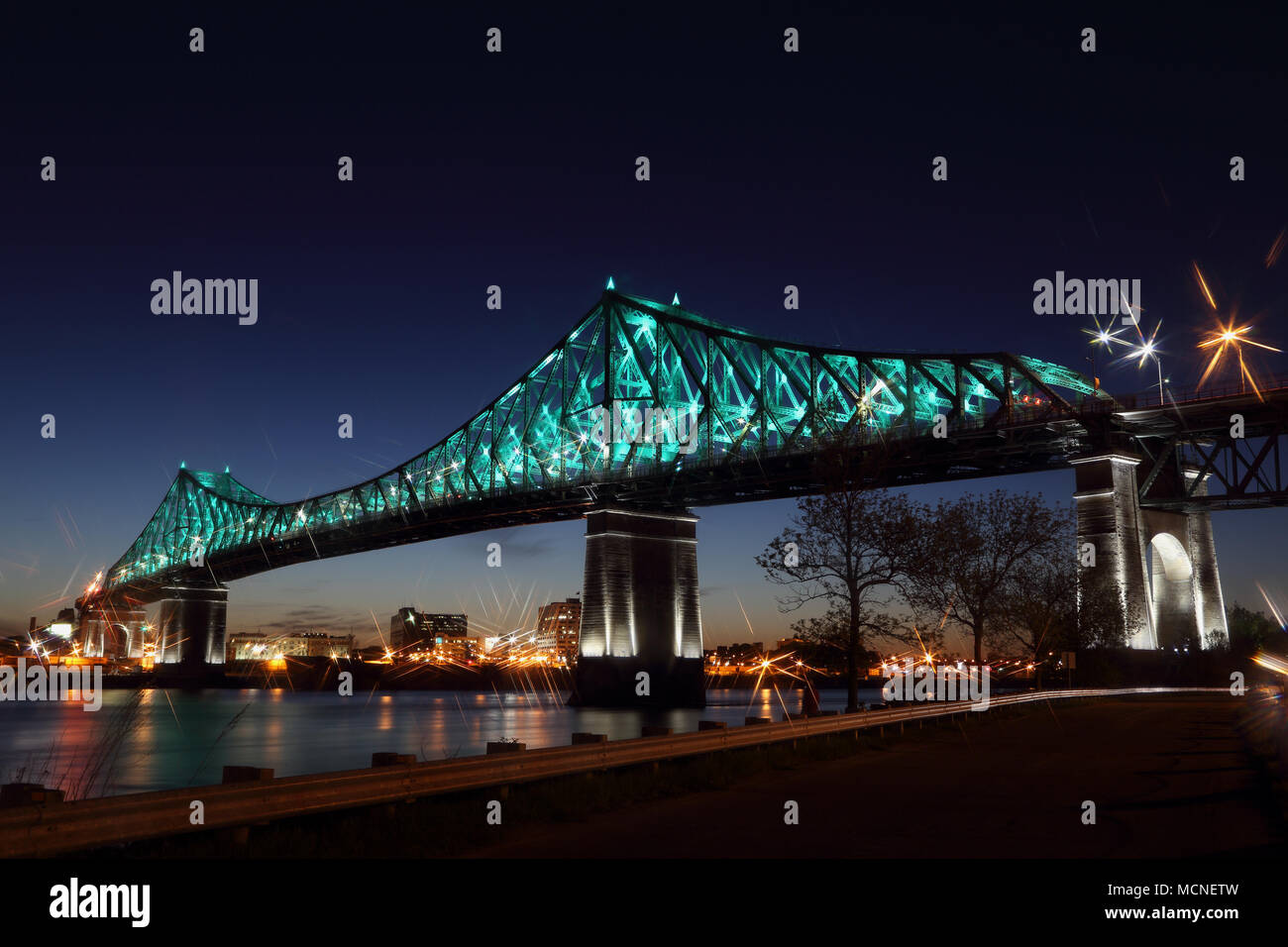 Jacques Cartier Bridge illuminazione in Montreal, riflesso nell'acqua. Montreal del 375 anniversario. Ponte panoramico silhouette colorato di notte. Foto Stock