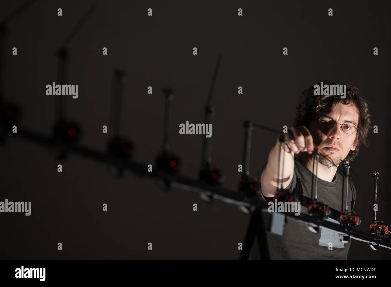 17 aprile 2018, Osnabrueck, Germania: l'artista multimediale Sebastian Neitsch (artista collettivo di quadratura) in piedi accanto alla sua installazione 'posizionamento dell'ignoto". Il trentunesimo European Media Festival è in esecuzione dal 18 al 22 aprile, la relativa mostra dal 18 aprile fino al 21 maggio 2018. Foto: Friso Gentsch/dpa Foto Stock