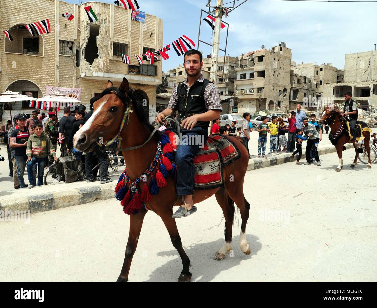 Damasco, Siria. Xvii Apr, 2018. Siriano passeggiate a cavallo nel quartiere Douma, a est di Damasco, Siria, il 17 aprile 2018. L'esercito siriano Douma catturato la scorsa settimana dopo il ritiro dei ribelli. Siri in Douma hanno scelto di utilizzare i cavalli per il trasporto come le strade hanno bisogno di ricostruzione dopo sei anni di guerra. Credito: Ammar Safarjalani/Xinhua/Alamy Live News Foto Stock