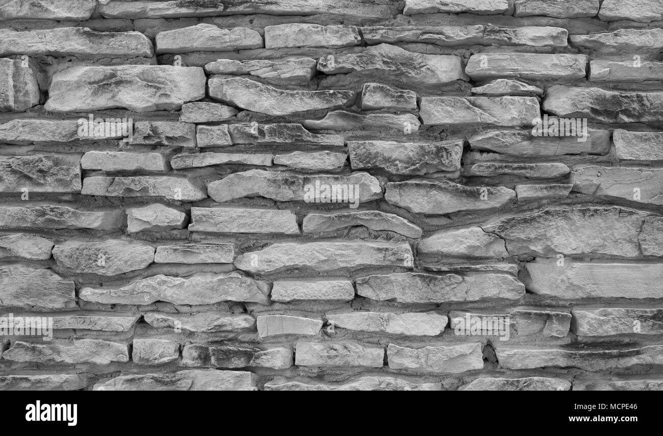 Grigio a muro di pietra texture. Naturale antica strada acciottolata come sfondo. Foto Stock