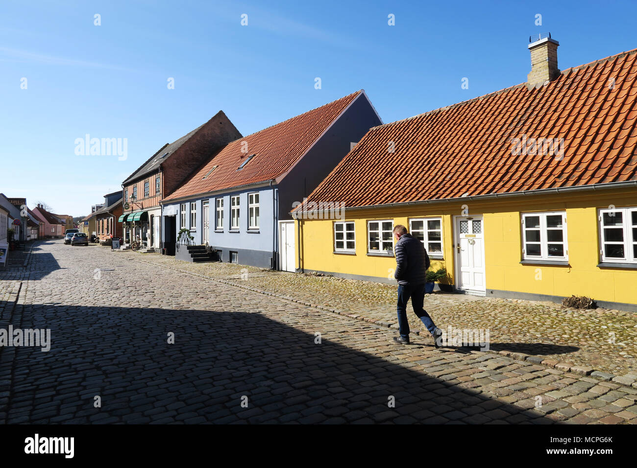 L'uomo cammina lungo la strada acciottolata nella città di Ebeltoft Danimarca Foto Stock