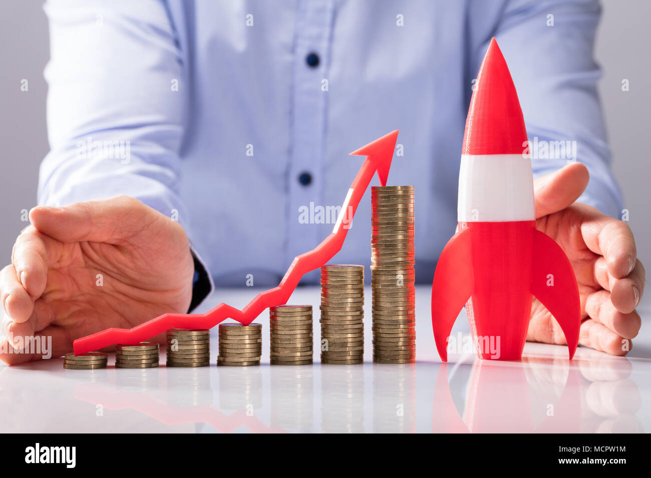 Close-up di un imprenditore la mano di protezione grafico crescente di monete con rucola Foto Stock