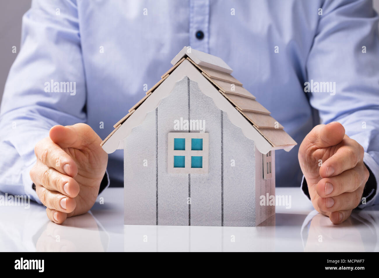 Close-up di una mano umana proteggere il modello della Casa Bianca sulla scrivania Foto Stock