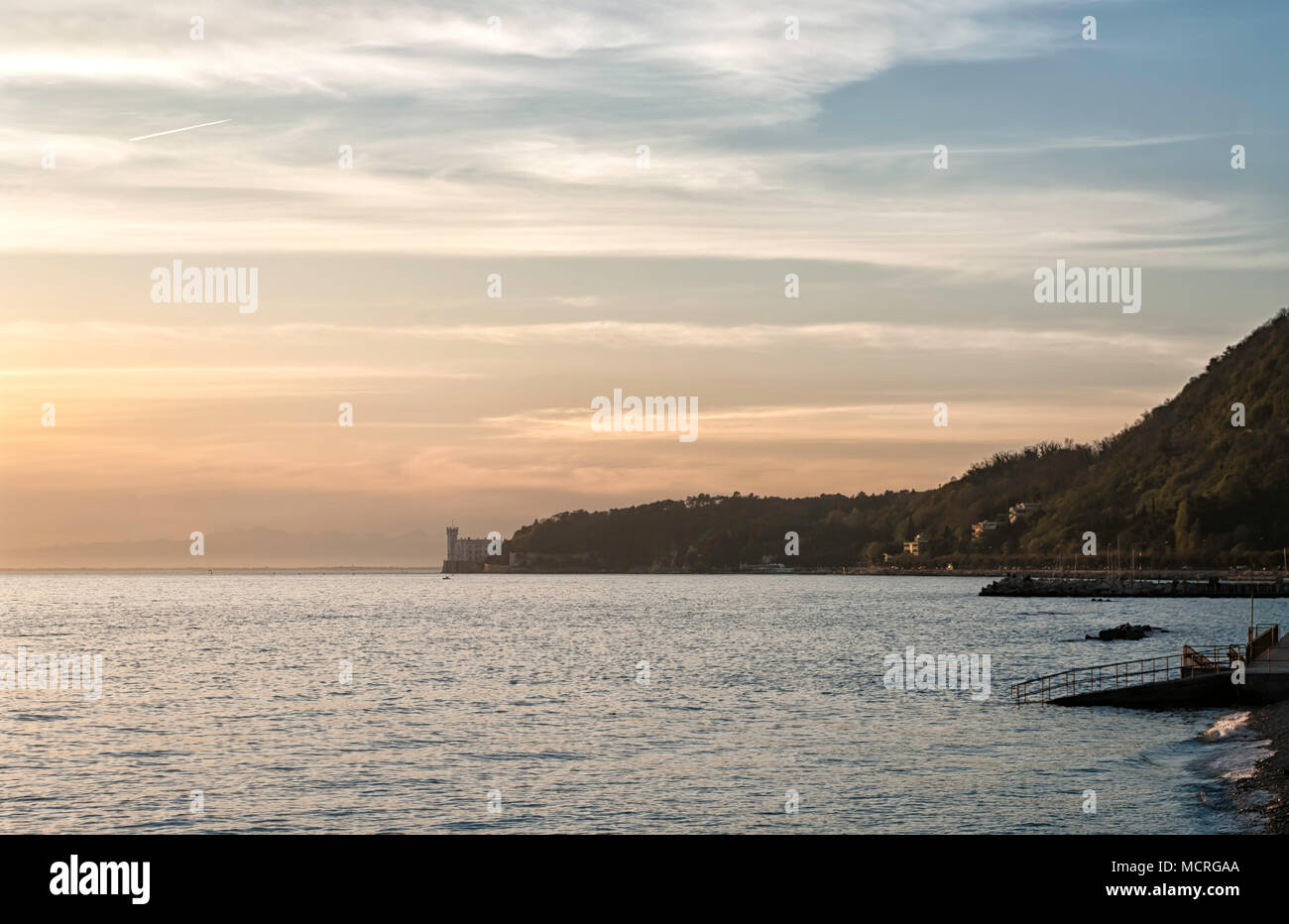 Vista del romantico golfo di Trieste e il bellissimo Castello di Miramare al tramonto. Il Castello di Miramare è un castello del XIX secolo costruito per l'arciduca austriaco Foto Stock