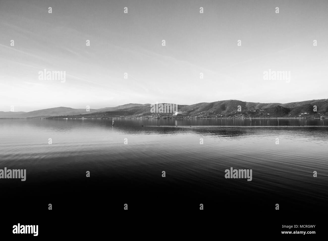 Bellissima vista del lago Trasimeno (Umbria, Italia), con colline e cielo riflettendo sull'acqua Foto Stock