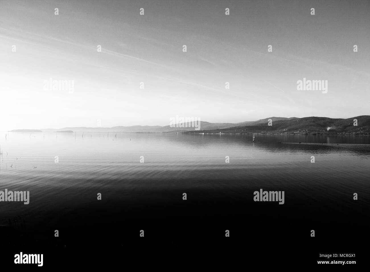 Bellissima vista del lago Trasimeno (Umbria, Italia), con colline e cielo riflettendo sull'acqua Foto Stock