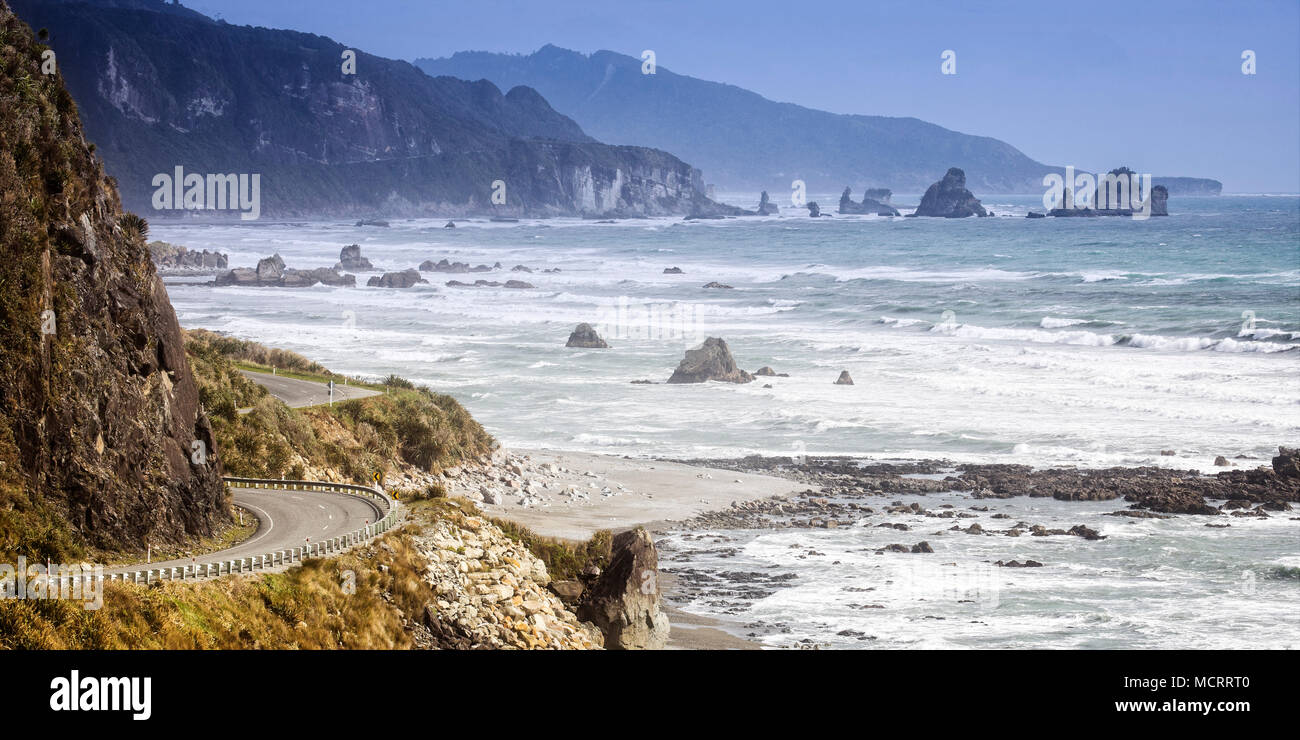 L'avvolgimento lato oceano strada lungo la costa Occidentale Regione del South Island, in Nuova Zelanda. Foto Stock