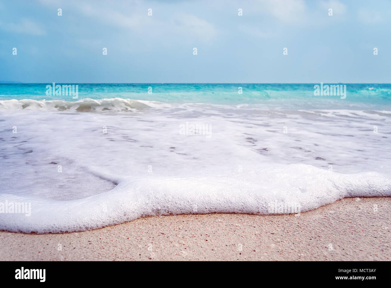 Bianco di schiuma di onde sulla spiaggia di Barcellona. Bianco di schiuma di mare close-up sulla spiaggia di sabbia di un'isola esotica. Paesaggio Marino Foto Stock