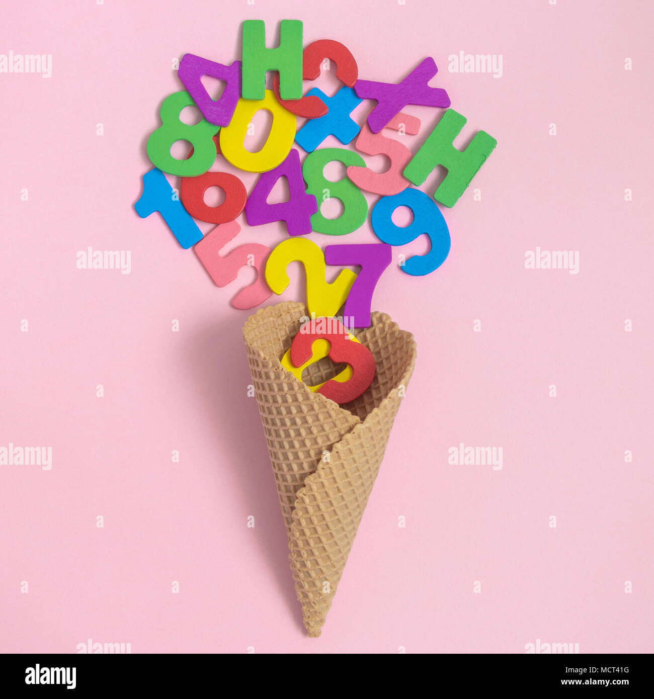 Cono gelato con legno colorato numeri e lettere sul rosa pastello minima di sfondo concetto creativo. Foto Stock