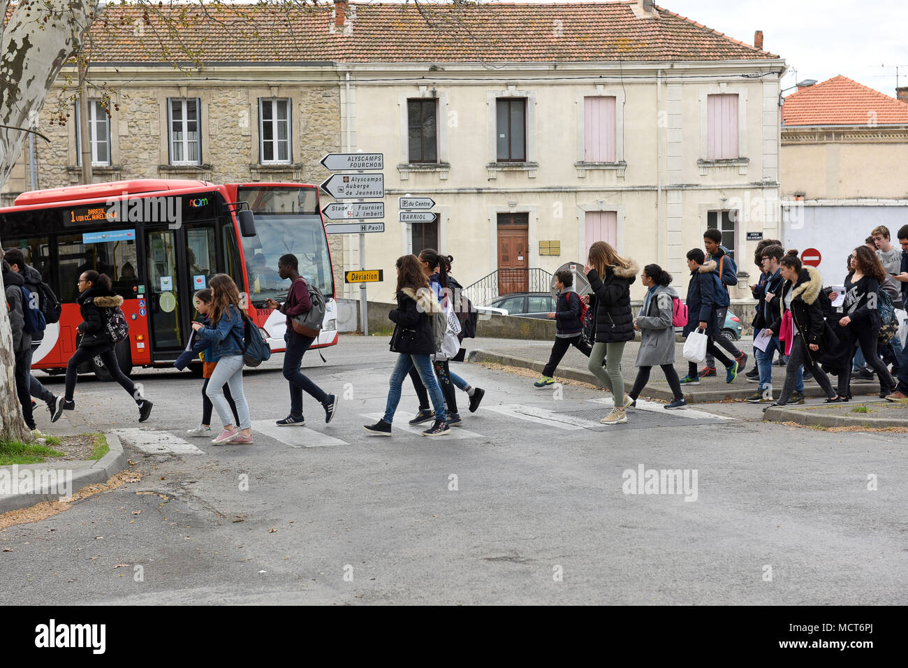 I bambini della scuola attraversando la strada sul passaggio pedonale in Arles, Francia Foto Stock
