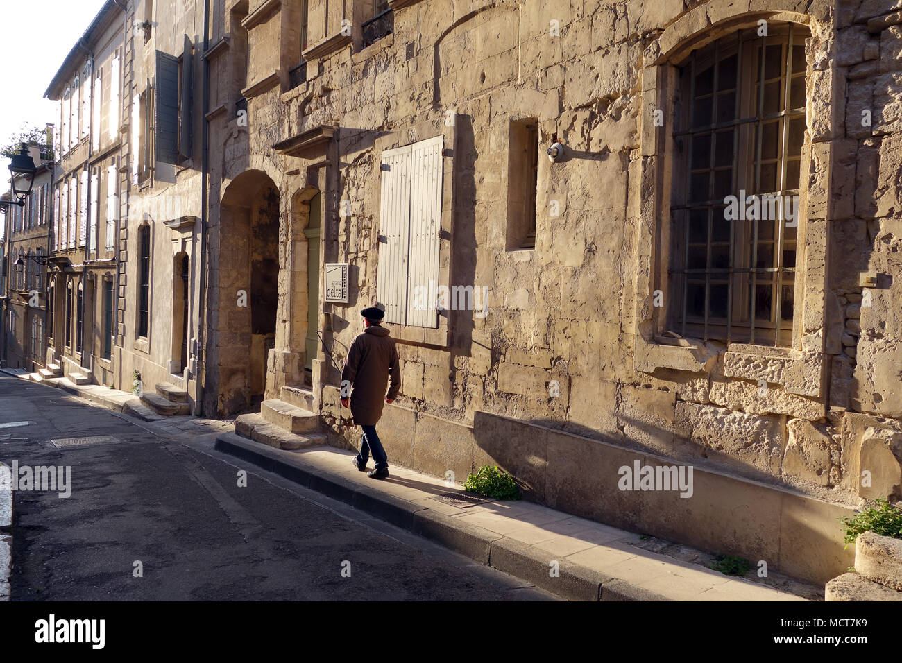 Lunghe ombre serali gettate da un uomo francese che indossa un berretto ad Arles in Francia Foto Stock