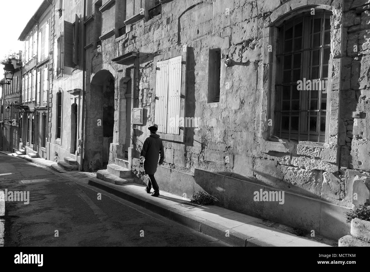 Serata di lunghe ombre proiettate da uomo francese indossando berry hat a Arles Francia Foto Stock
