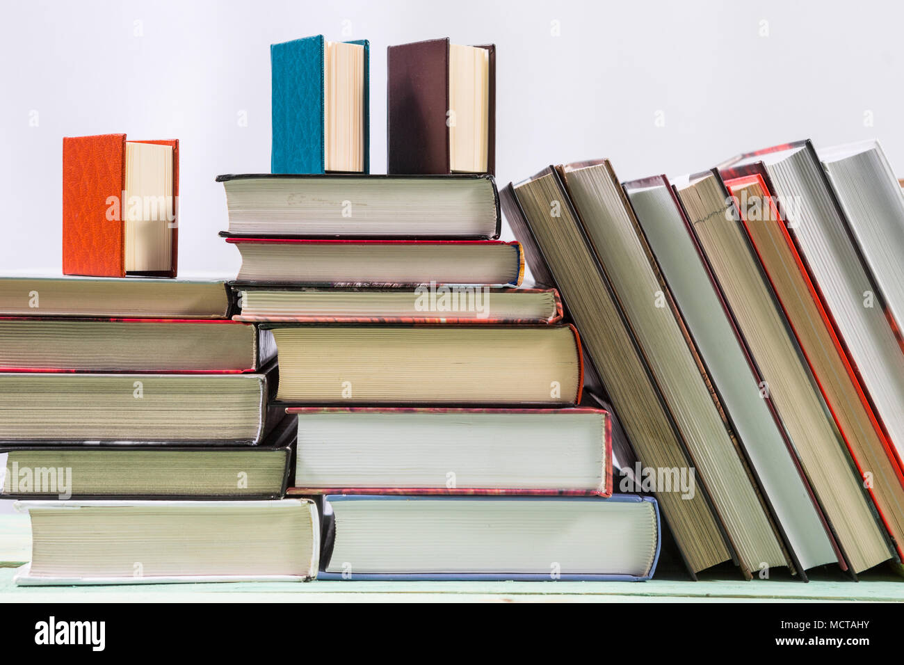 Pila di libri sullo sfondo di legno Foto Stock