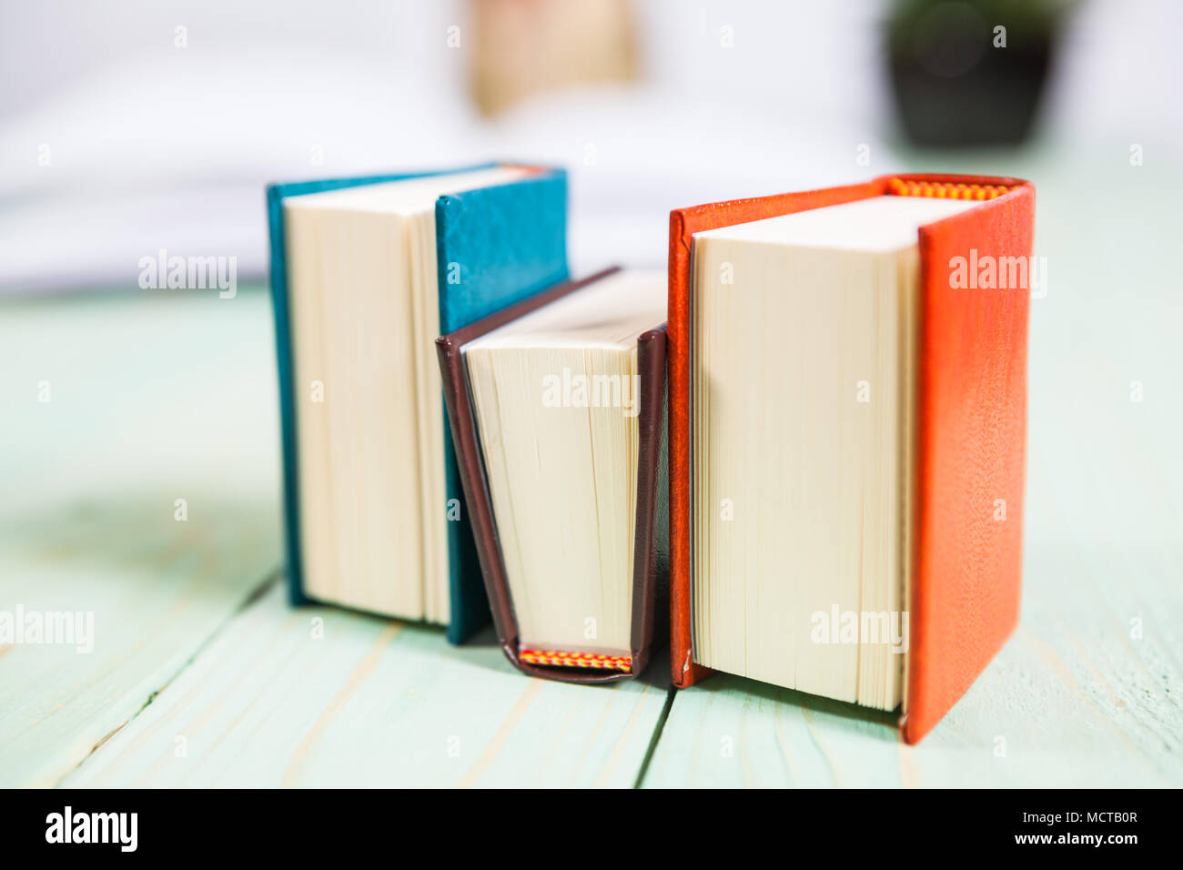 Pila di libri sullo sfondo di legno Foto Stock