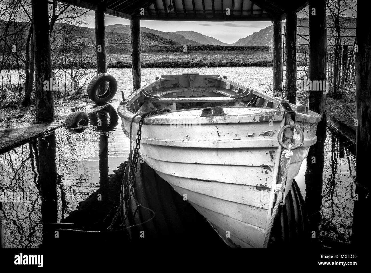 White barca a remi in barca casa su un lago di Donegal in Irlanda Foto Stock