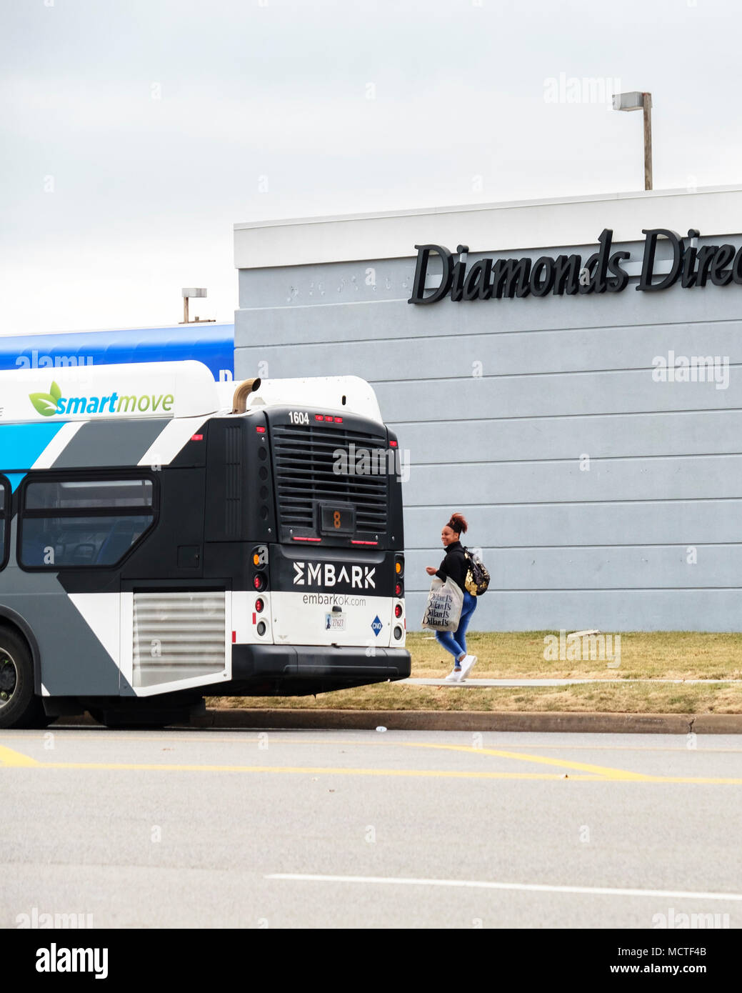 Un americano africano donna prepairs a bordo un Oklahoma City bus davanti di diamanti Direct store. Oklahoma City, Oklahoma, Stati Uniti d'America. Foto Stock
